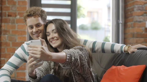 Happy young couple using smartphone at home. 動画素材 68540762