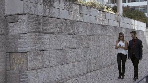 Happy young couple using smartphone on street Stock Footage 101383613