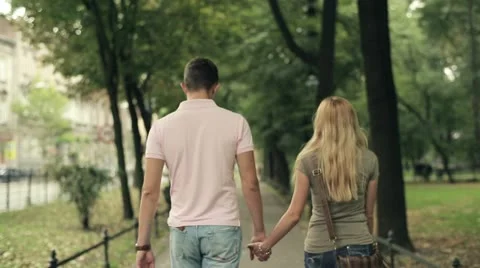 Happy young couple walking in the park, steadicam shot HD Stock Footage