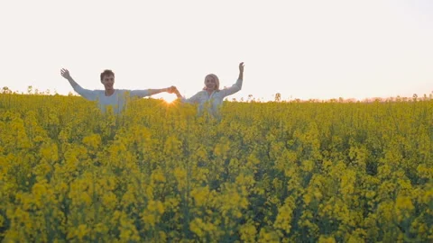 Happy young couple in yellow rape flowers field during sunset 動画素材 89426023