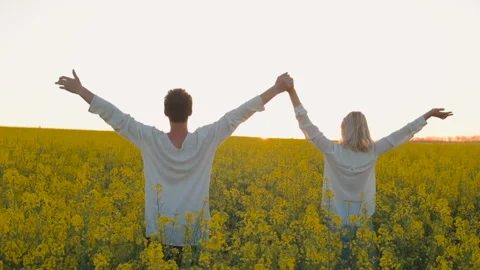 Happy young couple in yellow rape flowers field during sunset Vidéo 89426557