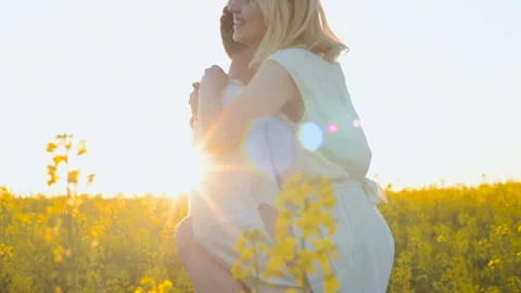 Happy young couple in yellow rape flowers field during sunset 库存影片 89428897