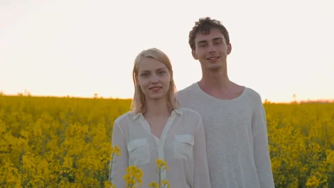 Happy young couple in yellow rape flowers field during sunset Vidéo 89429266