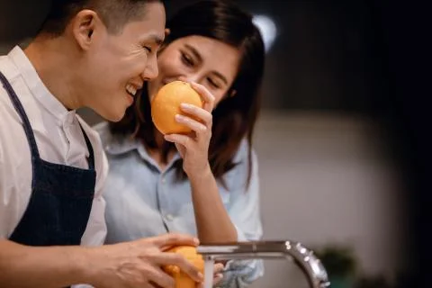 Happy Young Coupple in the Kitchen. Cleaning some Oranges to Preparing Delici Stock Photos