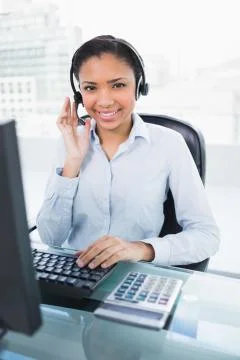 Happy young  dark haired operator answering a call Stock Photos