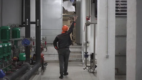 Happy young engineer throws documents up is in a technical room. at the factory Stock Footage 105607189