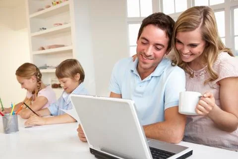 Happy young family looking and reading a laptop computer Stock Photos
