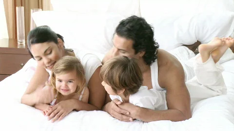 Happy young family lying in bed Stock Footage
