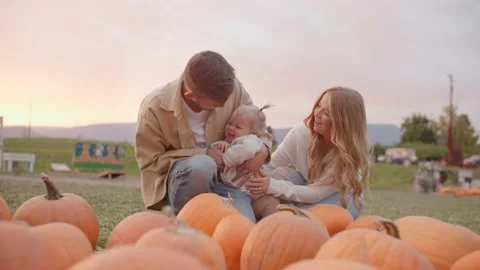 Happy young family at pumpkin patch, smiling and giggling 库存影片 219405367