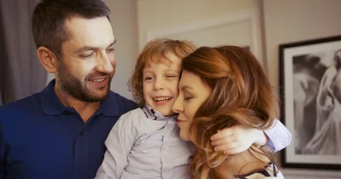 Happy young family spending time together at home. Son hugging parents. Mother Stock Footage