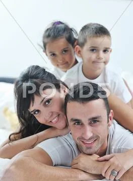 Happy young family in their bedroom Stock Photos