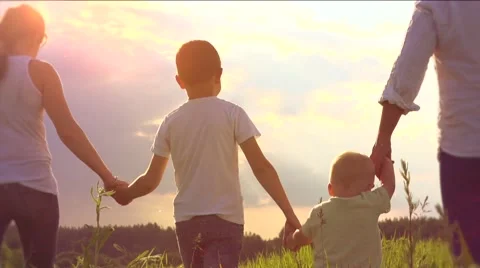 Happy young family with two children walking on summer field Stock Footage 59082467