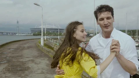 Happy young family of two dancing near the river in the city. Beautiful woman Stock Footage