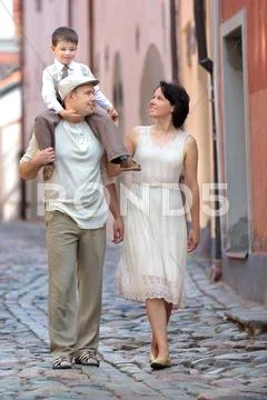 Happy young family walking in city street Stock Photos
