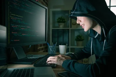 Happy young female hacker using computer crimes 写真素材