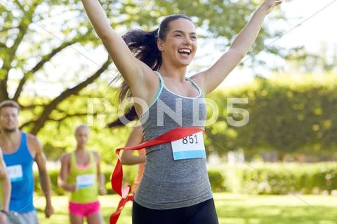 Happy young female runner winning on race finish Stock Photos