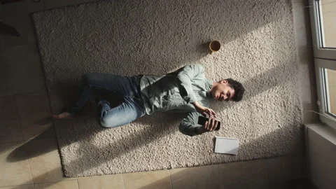 Happy young freelance programmer works at home on phone and laptop, writes in Stock Footage 231575342