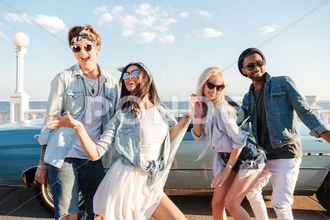 Happy young friends dancing outdoors in summer Stock Photos