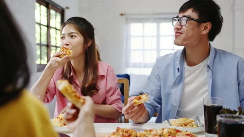 Happy young friends group having lunch eating pizza food at home. Stock Footage