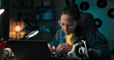 Happy young girl develops robotics skills, fixes electronics that power toy 動画素材 201205686