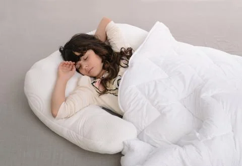 Happy young girl lying on pillow Stock Photos