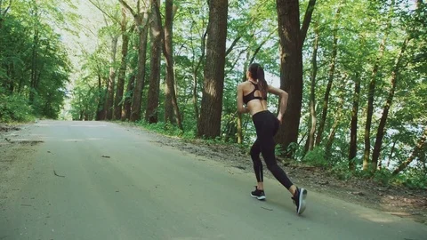 Happy young girl running in the morning park in 4K Stock Footage