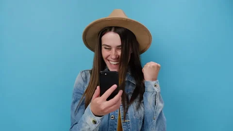 Happy young girl using mobile cell phone browsing doing winner gesture say yes Stock Footage 153081843