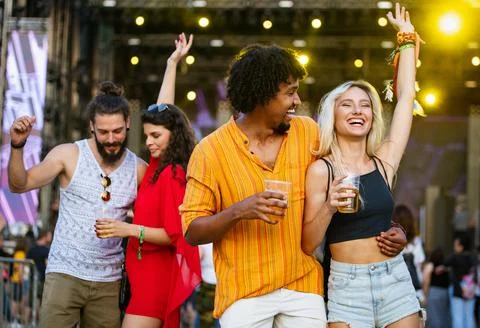 Happy young group of friends attending festivals at summer Stock Photos