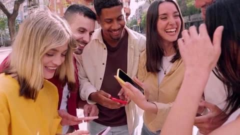 Happy young group of friends using smart mobile phones at city street Stock Footage 239626326