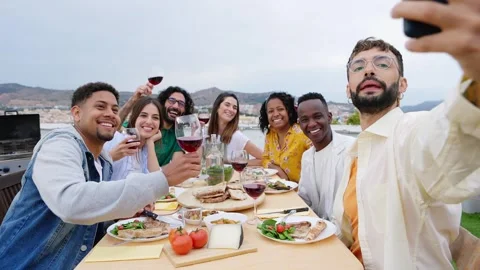 Happy young group of multiracial friends enjoying barbecue dinner on rooftop Stock Footage 241246292