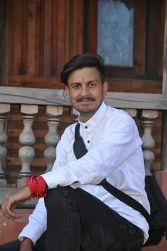 A happy young guy looking at camera while sitting on temple stairs Stock Photos