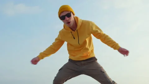 Happy young guy runs dancing moving his hands with his legs making funny faces Stock Footage 165606840