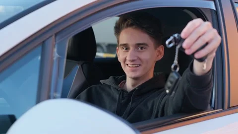 Happy young guy showing keys to a new car Stock Footage 265703516