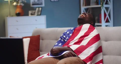 Happy young guy sitting on couch and watching comedic movie show on TV in Stock Footage 150396642