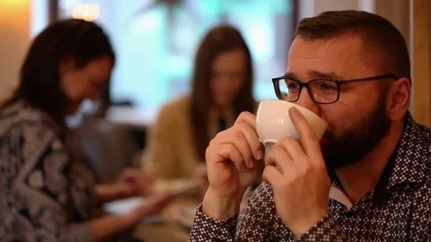 Happy, young handsome man smiling and drinking caffee in a cafe Stock Footage 72300601