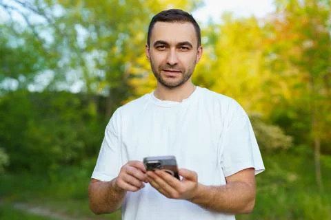 Happy young handsome man using phone at the park Foto stock