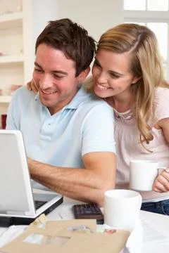 Happy young happy couple looking and reading a laptop computer Stock Photos