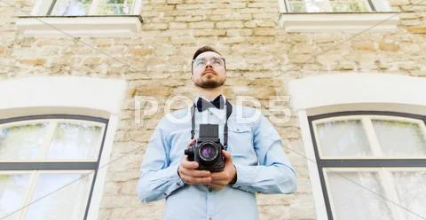 Happy Young Hipster Man With Film Camera In City