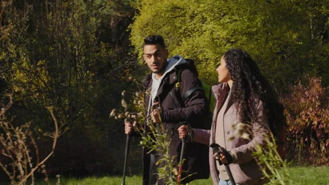 Happy young hispanic couple guy and girl tourists walking in forest on hike with 스톡 동영상 170389049