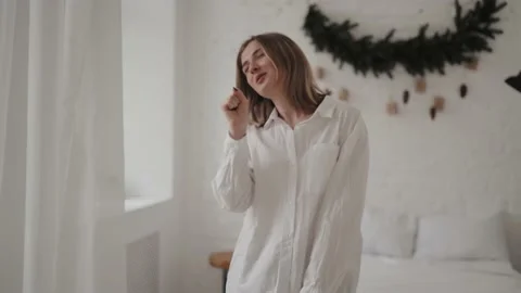 Happy young lady dancing and singing in apartment. Stock Footage 168748438