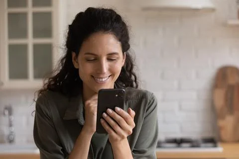 Happy young latina woman using smartphone applications. Stock Photos