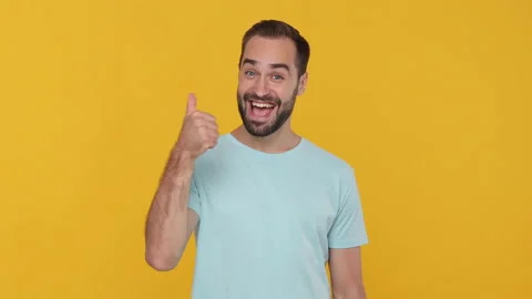 Happy young man 20s in basic casual blue t-shirt looking at camera expressive Video stock 148282756