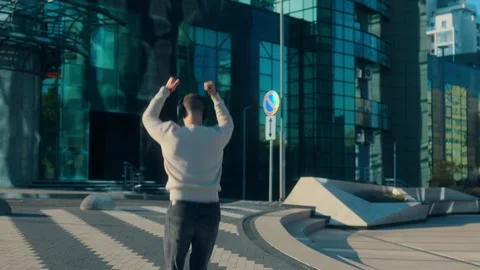 Happy young man with beard dancing and walking in modern city street Stock Footage 317554770