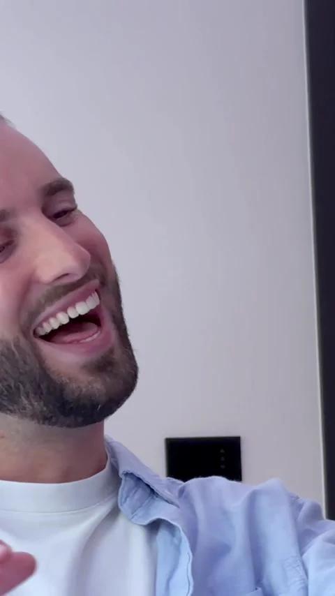 Happy young man with a beard smiling and waving while having a video conference Vídeos de archivo 345077971