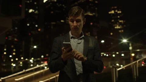 Happy young man is calling someone over his smartphone on a street Stock Footage 77784261