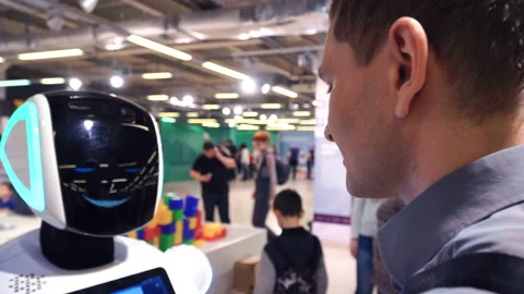 Happy young man communicate with robot. Robot head with camera close up. Expo Stock Footage 88689862