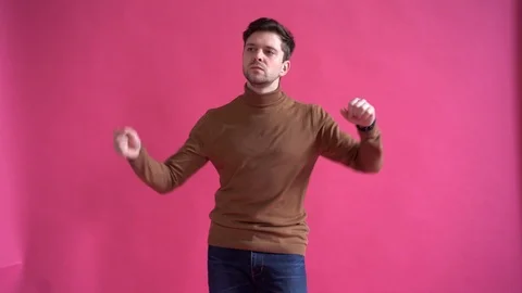 Happy young man dancing in studio isolated over pink background Stock Footage 123916308
