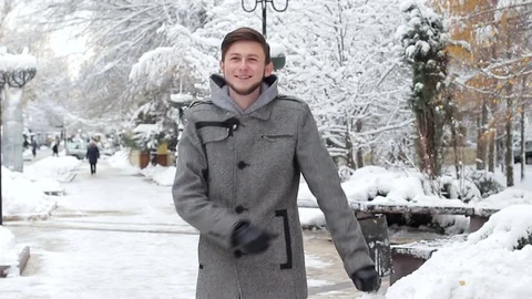 A happy young man dancing in a winter park Stock Footage 82705301