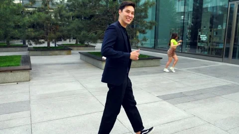 Happy young man grooving while walking in the city woman dances background 4K Vidéo 303132143