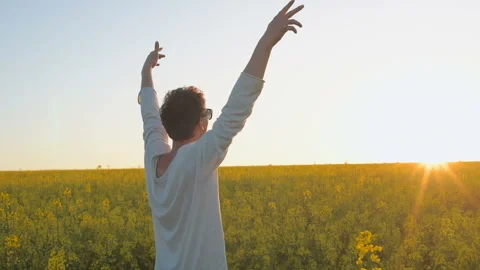 Happy young man having fun and dancing in yellow field during sunset Stock Footage 89447184